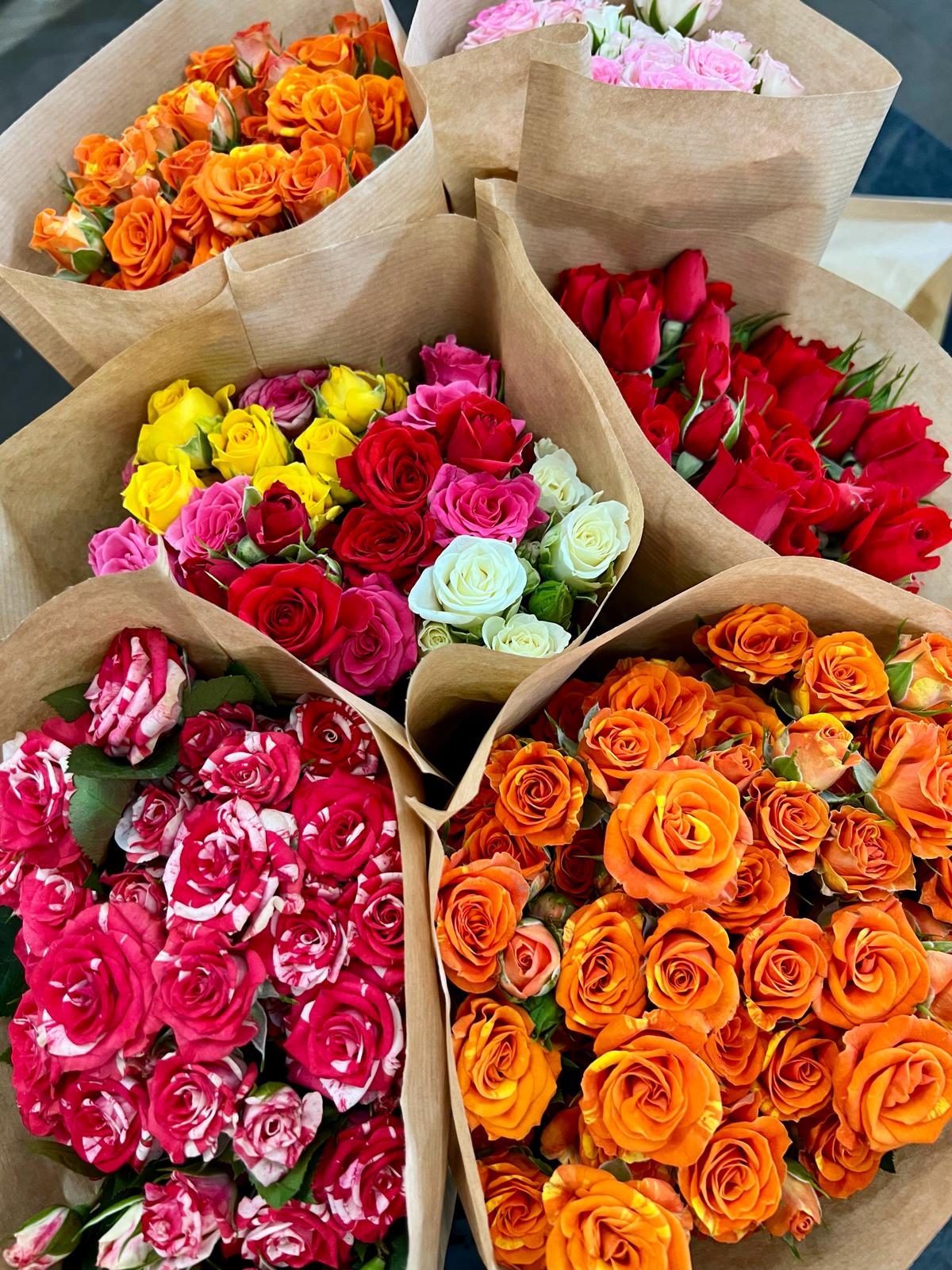 Ramos de rosas de distintos colores envueltos en papel